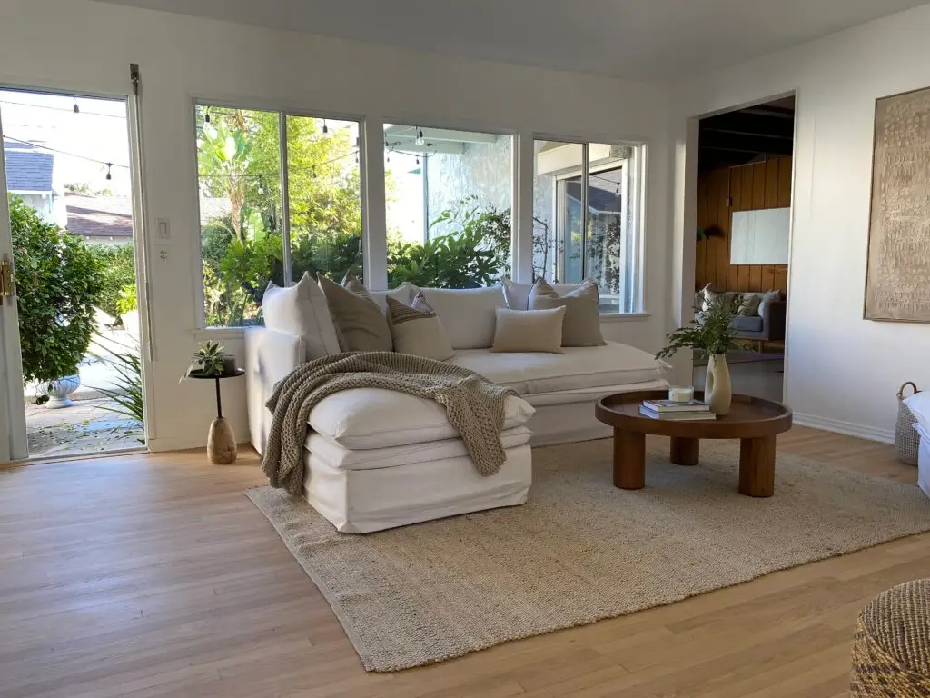 Living room at 736 Irving Drive Burbank Ranch Home featuring stone fireplace, wood floors, and natural light.