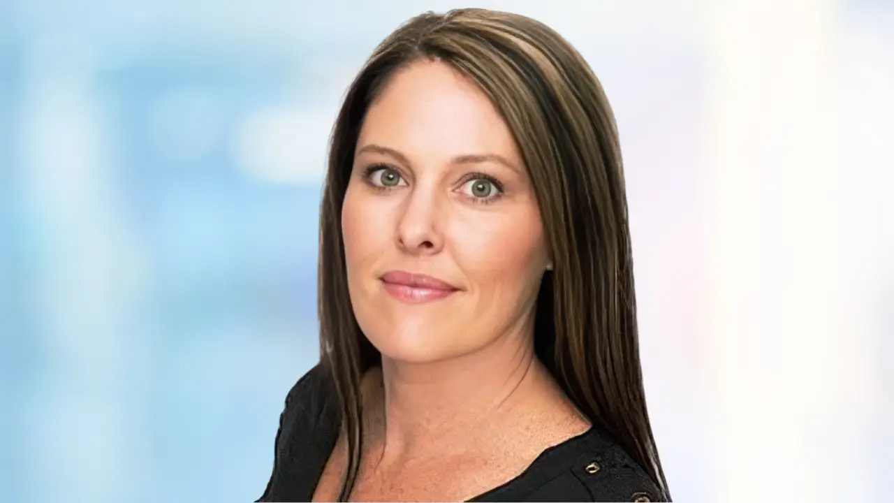 Professional headshot of Katie Anderson with a clean, light blue background